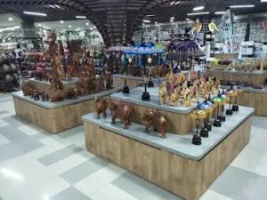Deretan patung kayu dan suvenir khas Bali di Krisna Oleh-Oleh, tempat belanja di Kuta yang terkenal dengan harga terjangkau dan koleksi lengkap untuk oleh-oleh wisatawan.