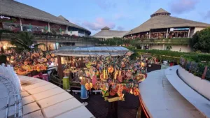 Pemandangan senja di Beachwalk Bali, tempat belanja di Kuta yang ikonik dengan desain tropis modern, deretan toko fashion, dan dekorasi warna-warni yang menarik perhatian wisatawan.