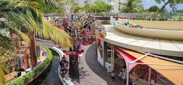 Suasana ceria di Beachwalk Shopping Center, salah satu tempat belanja di Kuta yang populer dengan desain modern terbuka dan toko-toko unik di tepi taman tropis.