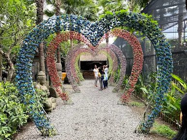 Terowongan bunga berbentuk hati warna-warni di Big Garden Corner Bali, spot foto favorit pengunjung dengan latar taman tropis yang instagramable.