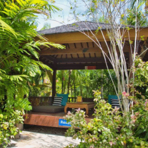 Gazebo pribadi yang nyaman di tengah taman tropis Waterbom Bali, dikelilingi tanaman hijau dan dilengkapi tempat duduk santai untuk beristirahat.