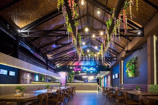  Tempat makan seafood murah di Jimbaran dengan interior modern, lampu gantung, dan dekorasi tanaman gantung.
