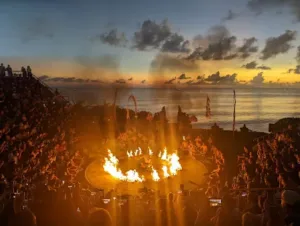Pertunjukan tari Kecak di Uluwatu Temple Bali saat matahari terbenam, dengan latar laut lepas dan suasana budaya khas Bali yang memukau wisatawan.