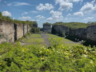 Area Lotus Pond di Garuda Wisnu Kencana Bali, dikelilingi tebing batu kapur tinggi dan hamparan rumput luas, cocok untuk acara budaya dan konser.