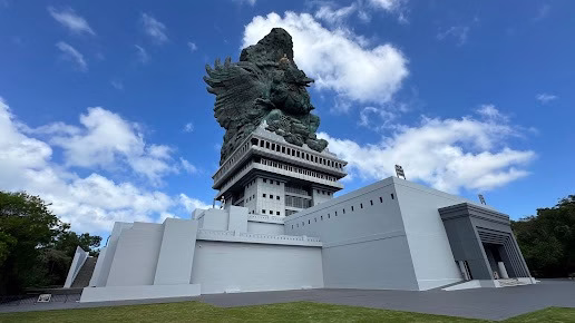 Patung utama Garuda Wisnu Kencana di Bali dengan latar langit biru cerah, menampilkan arsitektur megah dan simbol budaya Hindu yang ikonik. 