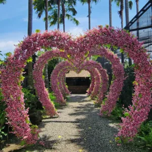 Terowongan bunga berbentuk hati yang estetik di Big Garden Corner Bali, spot foto populer dengan nuansa romantis di tengah taman tropis.