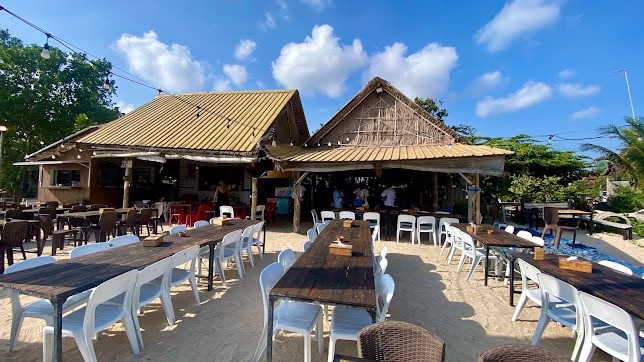  Tempat makan seafood murah di Jimbaran dengan suasana outdoor santai dan meja kayu di pasir.