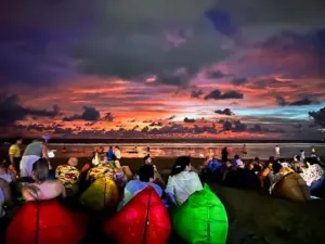 Colorful bean bags on the beach with stunning sunset view, a popular way to enjoy Nightlife Kuta Bali.