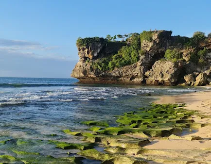 Pemandangan indah pantai dan tebing alami yang menawan dalam wisata Jimbaran Bali.